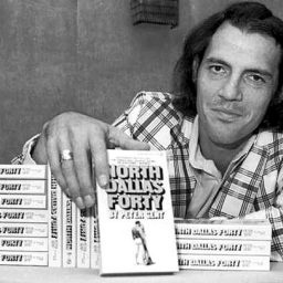 Former Dallas Cowboys flanker and author Peter Gent poses with copies of his bestseller, "North Dallas Forty," in New York. (Associated Press / August 26, 1974)