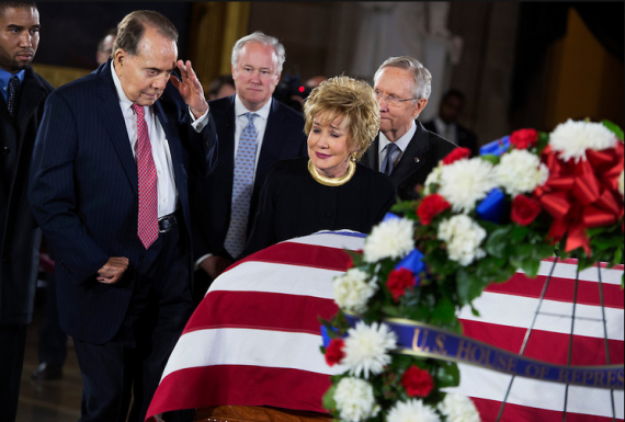 Former Sen. Bob Dole, R-Kan., salutes the casket of the late Sen. Daniel Inouye, D-Hawaii, as his body lies in state in the Capitol rotunda, as Dole's wife, former Sen. Elizabeth Dole, R-N.C., looks on. Bob Dole and Inouye knew each other since they were recovering from World War II battle wounds. Dole was assisted to the casket saying "I wouldn't want Danny to see me in a wheelchair." (Photo By Tom Williams/CQ Roll Call)