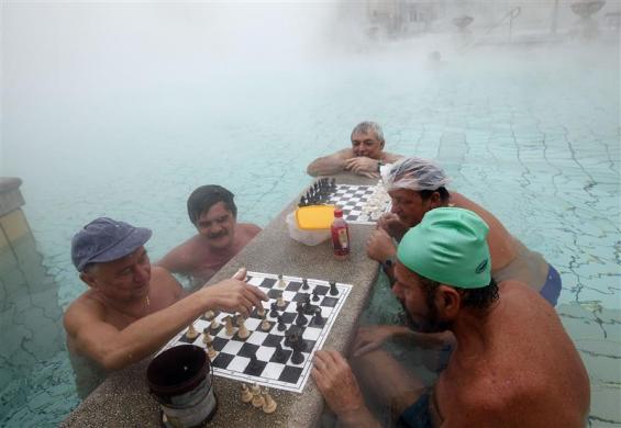 Bathers play chess while relaxing in Szechenyi Bath during a winter morning in Budapest