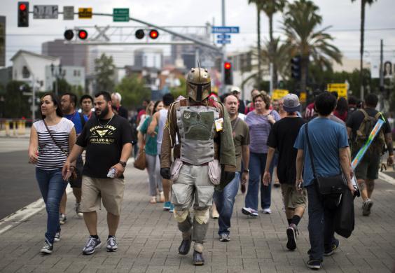 A person wearing a costume to resemble the Star Wars character of Boba Fett crosses the street during the 2014 Comic-Con International Convention in San Diego