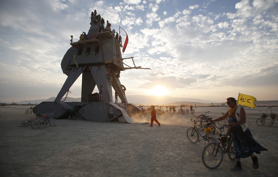 Participants interact with the Alien Siege Machine during the Burning Man 2014 "Caravansary" arts and music festival in the Black Rock Desert of Nevada