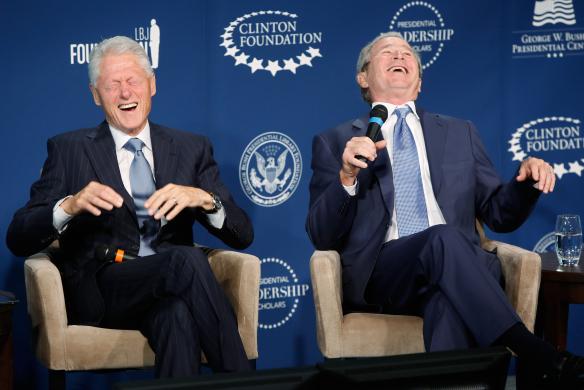 Former U.S. presidents Bill Clinton and George W. Bush laugh on stage during a Presidential Leadership Scholars program event at the Newseum in Washington