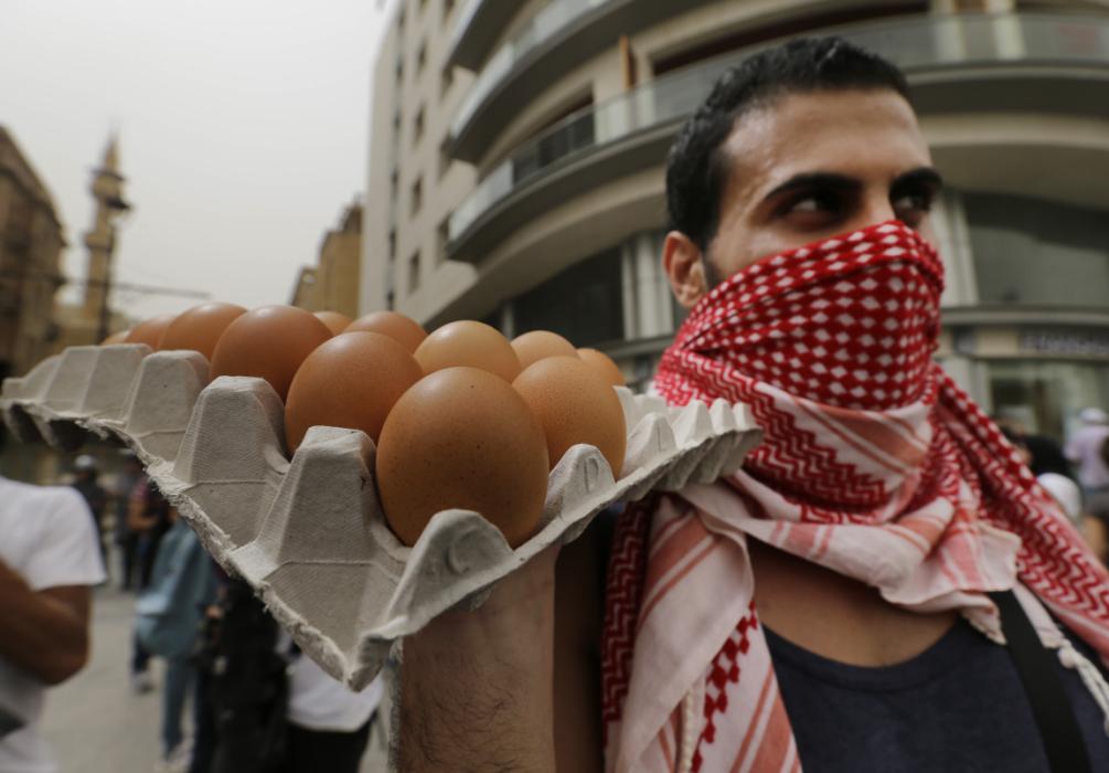 A Lebanese anti-government protester holds eggs, to throw them on the convoys of Lebanese politicians arriving at the parliament building, during a protest against the on-going trash crisis and government corruption, in downtown Beirut, Lebanon, Wednesday, Sept. 9, 2015. Lebanon's prime minister says he hopes that political talks between senior politicians will help end government paralysis that has sparked angry street protests. (AP Photo/Hassan Ammar)