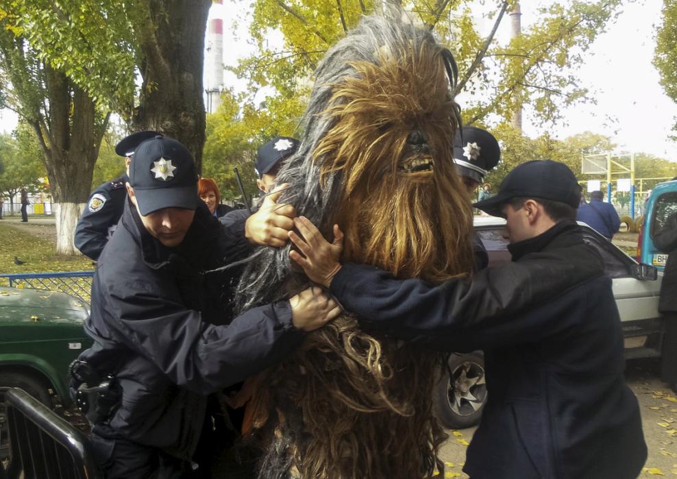 Policemen detain a person dressed as Star Wars character Chewbacca during a regional election near a polling station in Odessa, Ukraine, October 25, 2015. Ukrainians go to the polls on Sunday to appoint mayors and council heads to regional seats. The person was detained for illegal election-day campaigning, according to local media. REUTERS/Ihor Babak      TPX IMAGES OF THE DAY