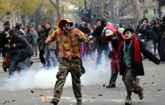 Activists run as they clash with policemen during a protest ahead of the 2015 Paris Climate Conference, in Paris, Sunday, Nov. 29, 2015. More than 140 world leaders are gathering around Paris for high-stakes climate talks that start Monday, and activists are holding marches and protests around the world to urge them to reach a strong agreement to slow global warming. (AP Photo/Christophe Ena)