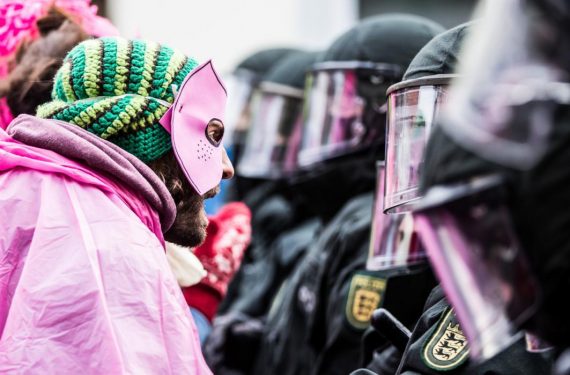An activist  in pink clothes and a mask clashes with riot police during a demonstration organized to protest against the Federal Congress held by far-right NPD on Nov. 21, 2015 in Weinheim, Germany. (Simon Hofmann/Getty Images)