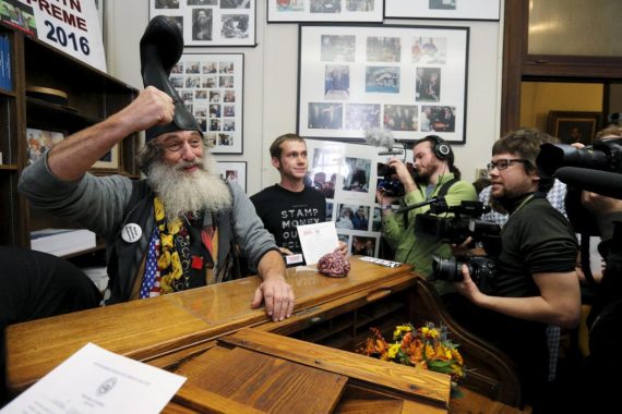 U.S. Democratic presidential candidate Vermin Supreme (L) reacts after filing his declaration of candidacy to appear on the New Hampshire primary election ballot in Concord, New Hampshire, November 20, 2015. To appear on the primary ballot candidates must sign a declaration affirming that they meet the Constitutional requirements to run for President and pay a $1,000 filing fee. REUTERS/Brian Snyder      TPX IMAGES OF THE DAY