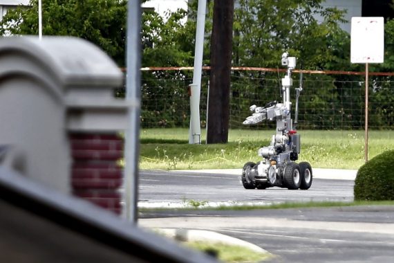 HUTCHINS, TX - JUNE 13: Dallas Police use a robot to gain access to an armoured van, which authorities believed was rigged with explosives, and was driven by a suspect who attacked Dallas Police Headquarters in Dallas, Texas, June 13, 2015. A lone shooter in an armored van, believed to be rigged with explosives, opened fire on the Dallas Police Headquarters early Saturday morning. The shooter reportedly unleashed multiple rounds and planted explosive devices around the station before leading police on a chase that ended in a standoff in the parking lot of a fast food resturant. (Photo by Stewart F. House/Getty Images)