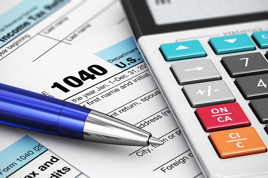 Macro view of 1040 US Tax Form, calculator and ballpoint pen