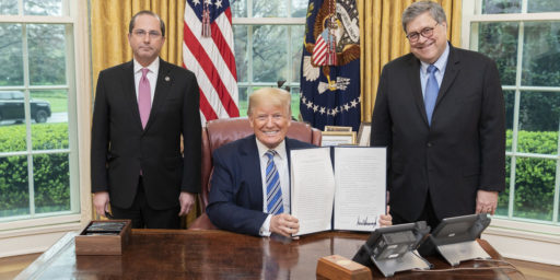 President Donald J. Trump, joined by Health and Human Services Secretary Alex Azar, left, and Attorney General William Barr, displays his signature after signing an Executive Order to Prevent Hoarding and Price Gouging, Monday, March 23, 2020, in the Oval Office of the White House. (Official White House Photo by Shealah Craighead)