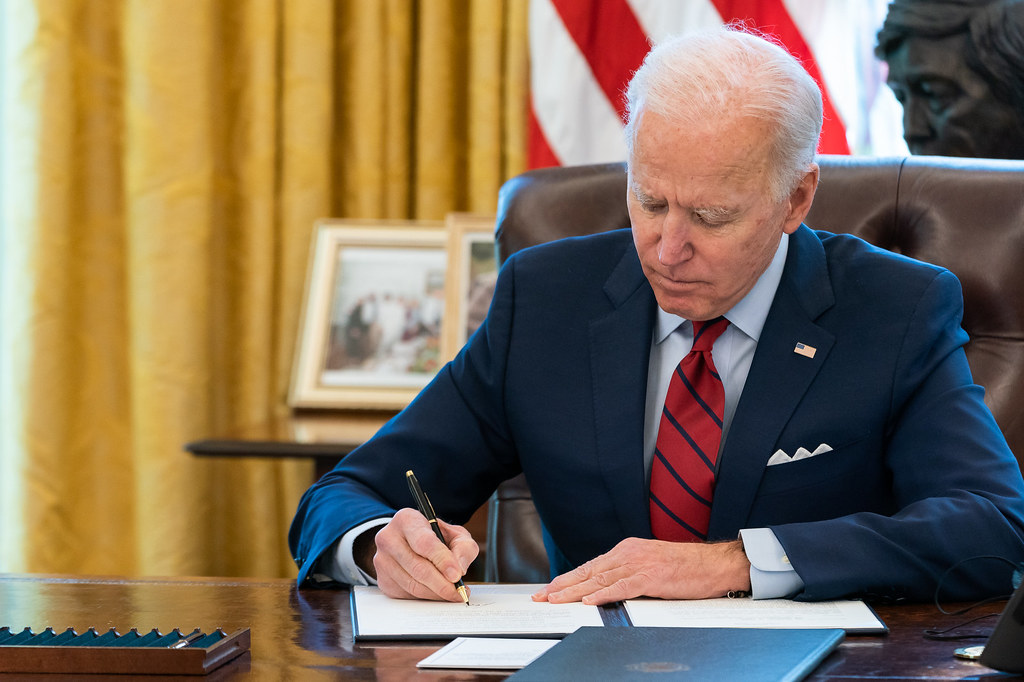 President Joe Biden signs two executive orders on healthcare Thursday, Jan. 28, 2021, in the Oval Office of the White House.