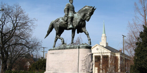 Portrait of a Robert E. Lee astride his horse, Traveller. Lee is bare-headed, wearing a military uniform, sitting very erect with his sword at his proper left side. His proper left hand is on the reins, and his proper right hand hangs down, holding his hat. The horse is in a walking pose with his proper left front hoof raised. On the front of the base is a relief depicting a fighting eagle with wings expanded, surrounded by clusters of oak leaves. On the back of the base is a relief of a garland.