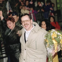 Terry Anderson, center, accompanied by his sister Peggy Say, left, and Madeleine Bassil, right, in Germany, Dec. 5, 1991. (AP Photo/Thomas Kienzle, File)