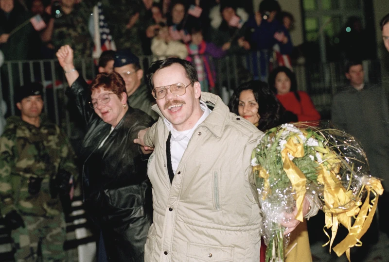 Terry Anderson, center, accompanied by his sister Peggy Say, left, and Madeleine Bassil, right, in Germany, Dec. 5, 1991. (AP Photo/Thomas Kienzle, File)