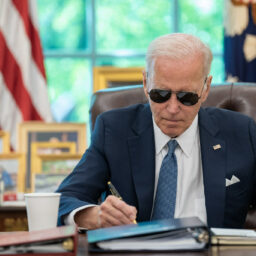 President Joe Biden wears his aviator sunglasses while working at the Resolute Desk, Tuesday, June 13, 2023, in the Oval Office.