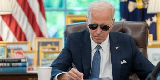 President Joe Biden wears his aviator sunglasses while working at the Resolute Desk, Tuesday, June 13, 2023, in the Oval Office.